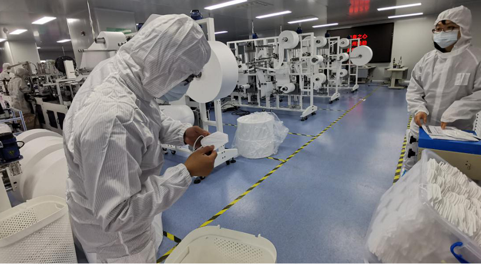 业务骨干王能斌、陈梅芳检查医用防护口罩质量和生产记录